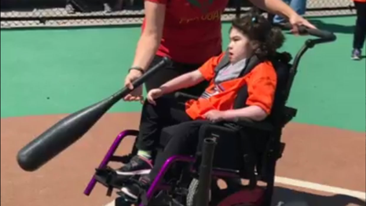 Child in wheelchair playing baseball