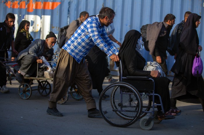 Picture of a man pushing a woman in a wheelchair.