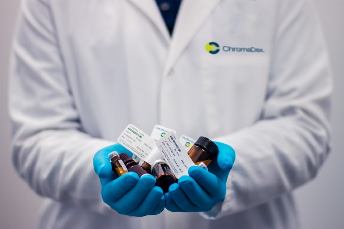 Picture of a doctors hands full of medical tubes and medication.