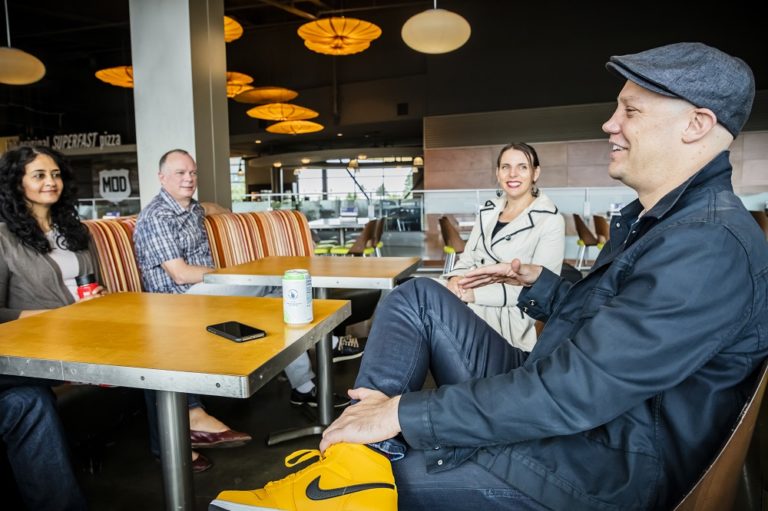 Craig Cincotta (right) talks with former and current team members (from left) Hanady Kader, Greg Sullivan and Annie Spencer.