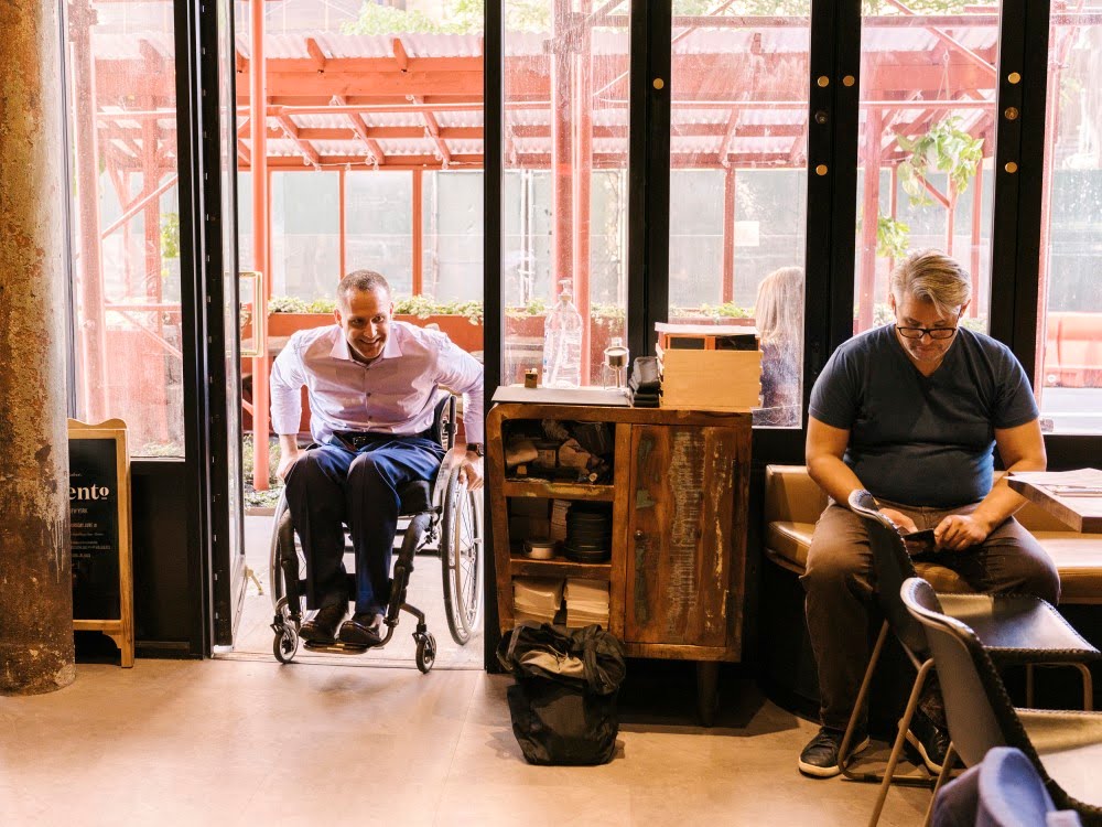 Yannick Benjamin entering restaurant on his wheelchair for an opening with head chef Oscar Lorenzzi