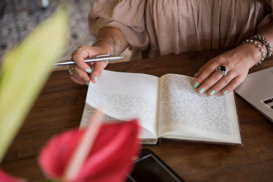 Picture of Celinne Da Costa flipping through an open book.