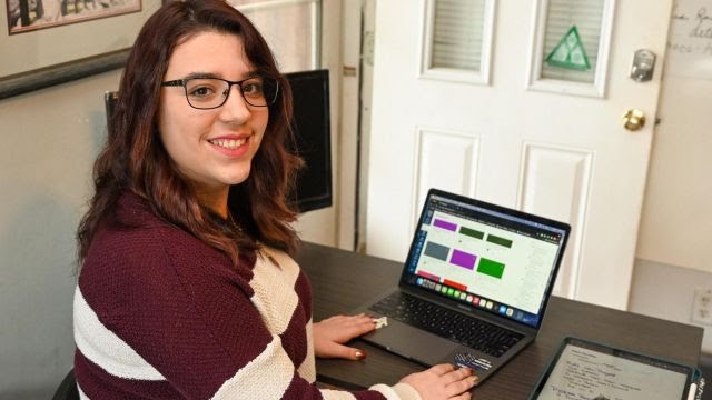 Picture of Maria Marks using her laptop in her home sitting down.