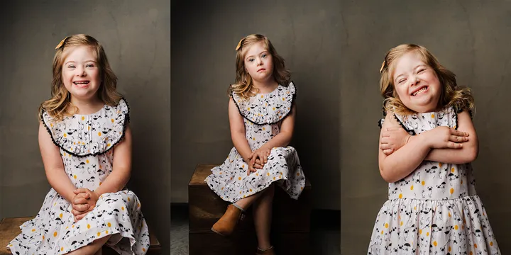 Picture of a little girl with downs syndrome posing for the picture.