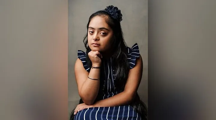 Picture of a young woman with down syndrome posing for the picture.