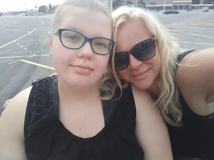 Picture of Emma and her mother in a parking lot.