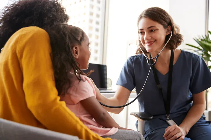 Picture of a young girl at the doctors getting checked up.