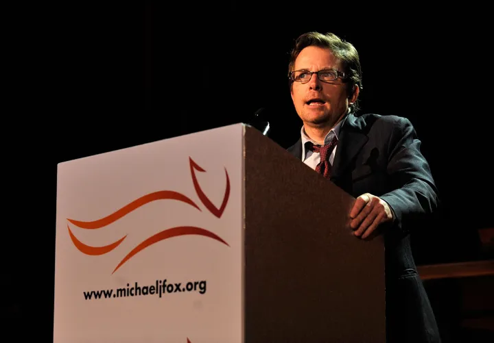 Picture of Michael J. Fox speaking onstage at a fundraiser for the Michael J. Fox Foundation.