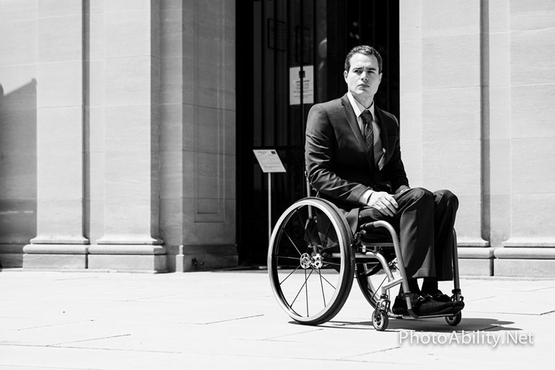 Black and white photo of a man in his wheelchair.