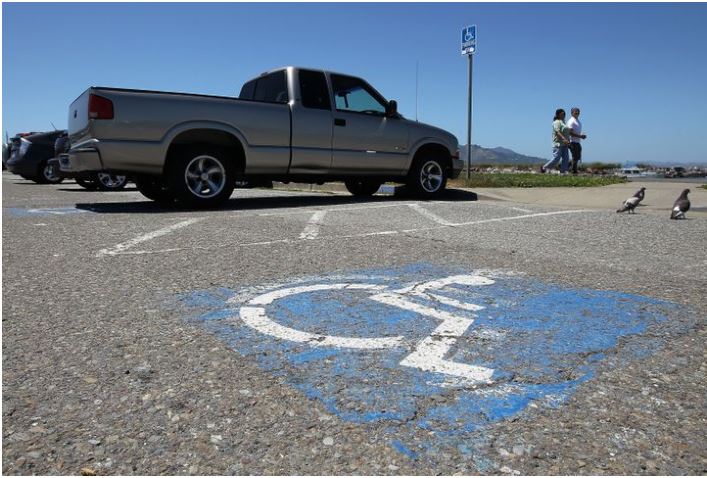 Picture of a truck parked in a handicap parking spot.