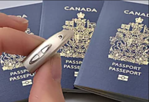 Picture of a haearing aid with three Canadian passports in the background.