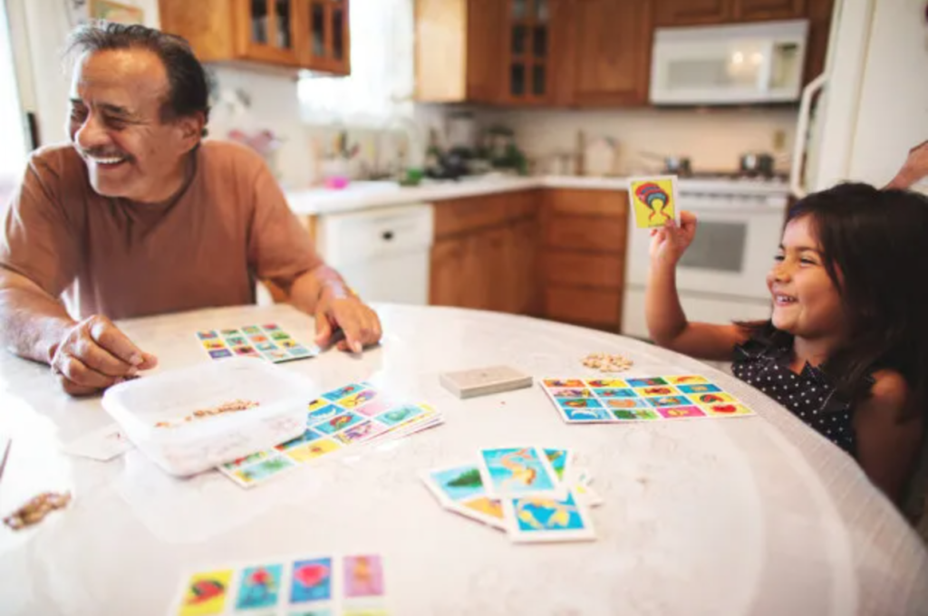 Picture of a father playing card games with his daughter.