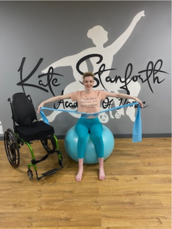 Picture of Kate Stanforth on a yoga ball in her dance studio.