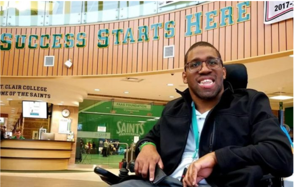 Image of Kevin McShan in his wheelchair sitting in St. Clair College.