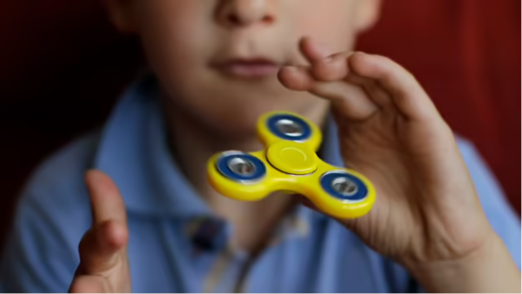 Picture of a kid using a fidget spinner.