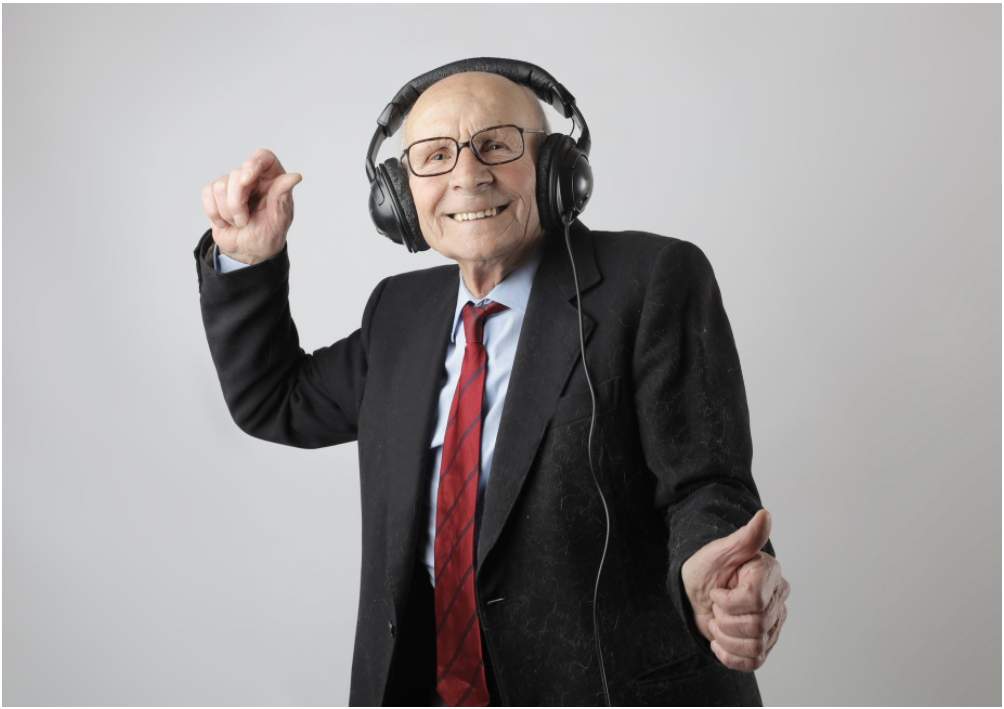 Picture of an older man dancing with headphones on.