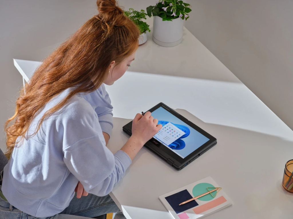 Picture of a teenage girl using her haptop as a tablet using a touch pen.