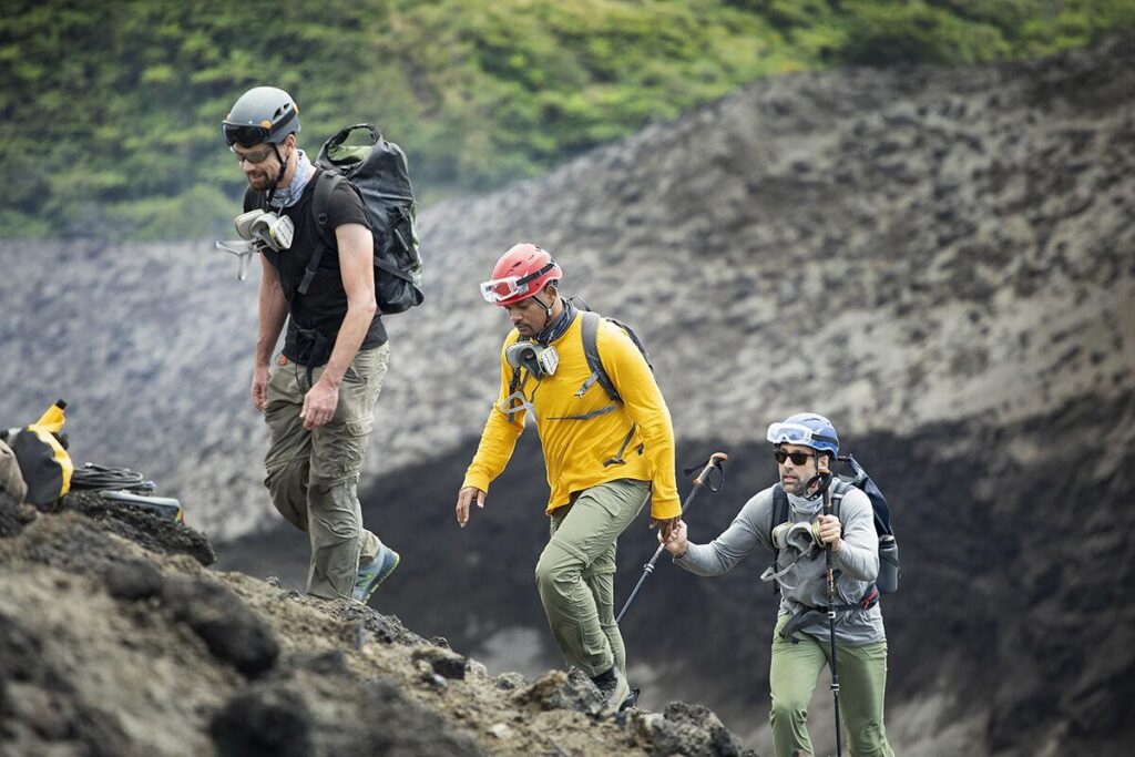 From left, vulcanologist Jeff Johnson, Will Smith and Erik Weihenmayer prepare to descend into the Mount Yasur volcano to install sensors.  National Geographic for Disney+/Kyle Christy