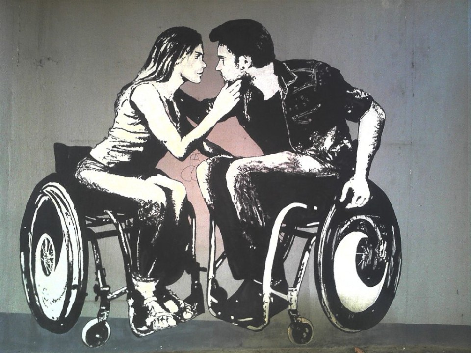Man and Woman each on a wheelchair looking into eachothers faces