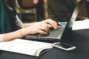 young womans hands typing on laptop