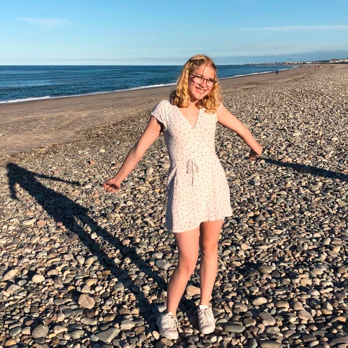 Cara Daly on a rock beach.