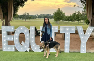 Haben Girma, stands outdoors with her seeing-eye dog, Mylo, at Deloitte’s Chief DEI Forum in June 2023.