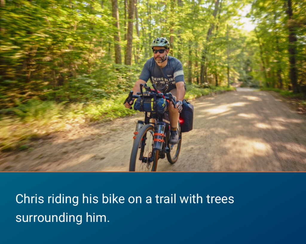 Chris riding his bike on a tráiler with trees surrounding him.